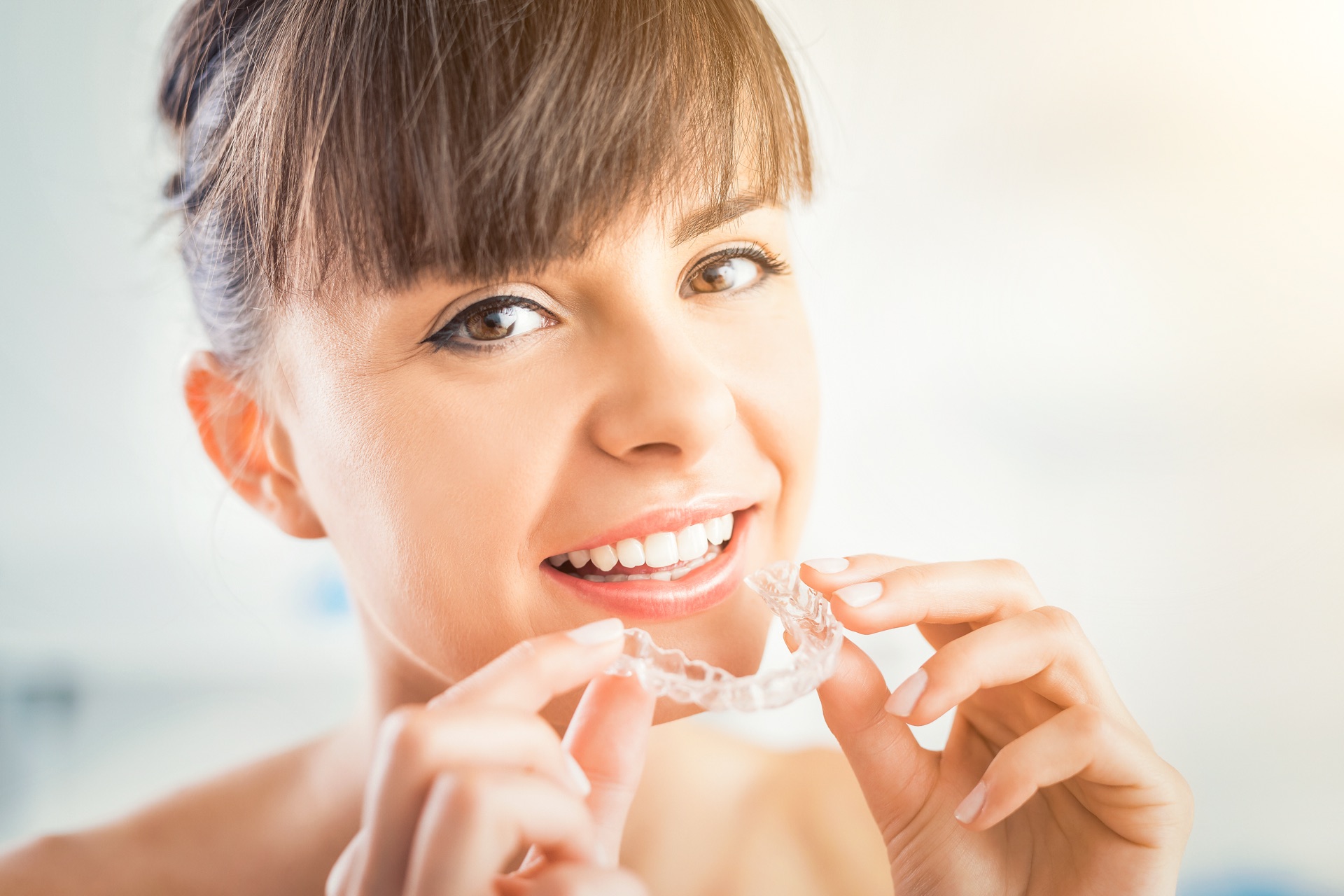 Young woman smiling with a nearly invisible aligner